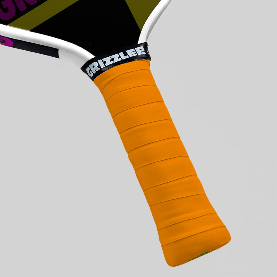 Close-up of a Pickleball Paddle with an neon orange grip and 'Grizzlee' branding on a gray background